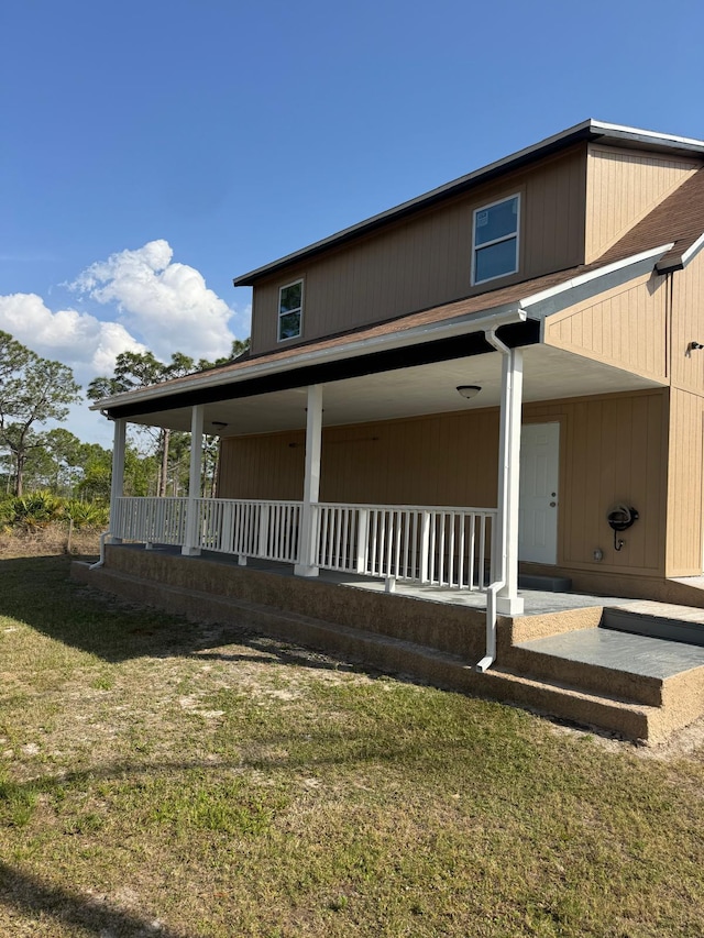 exterior space featuring covered porch and a front lawn