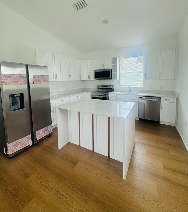 kitchen featuring dark wood finished floors, visible vents, a sink, stainless steel appliances, and white cabinets
