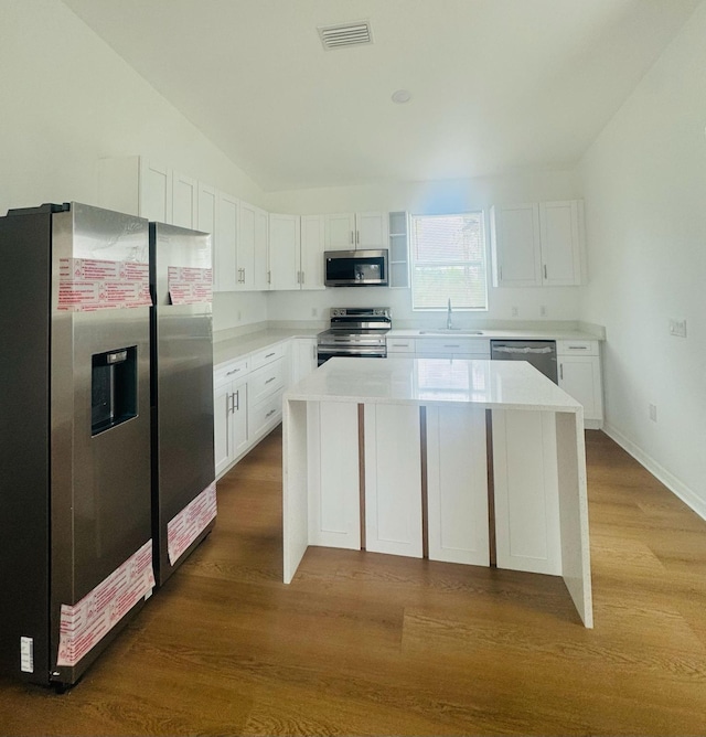 kitchen featuring a sink, stainless steel appliances, visible vents, dark wood-style flooring, and white cabinetry