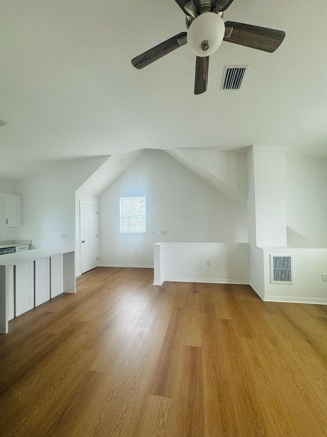 additional living space with visible vents, light wood-style flooring, baseboards, and ceiling fan