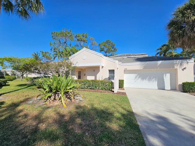 view of front of home featuring an attached garage, driveway, stucco siding, and a front lawn