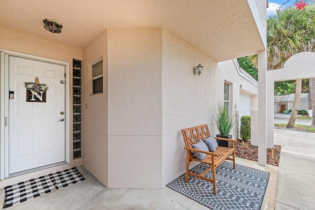 view of exterior entry featuring stucco siding and covered porch