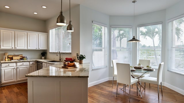 kitchen with dark wood-style flooring, light stone counters, a sink, white cabinetry, and recessed lighting