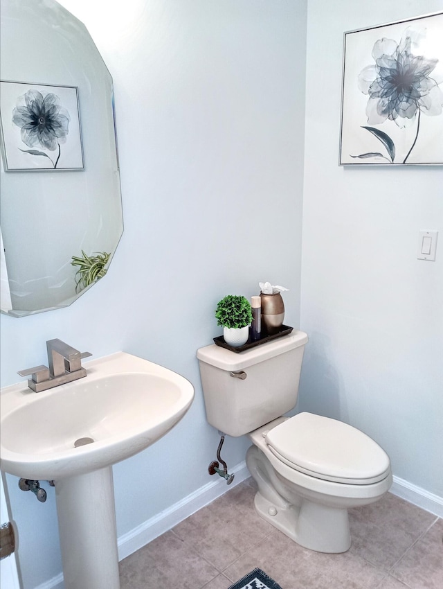 bathroom with baseboards, tile patterned floors, and toilet