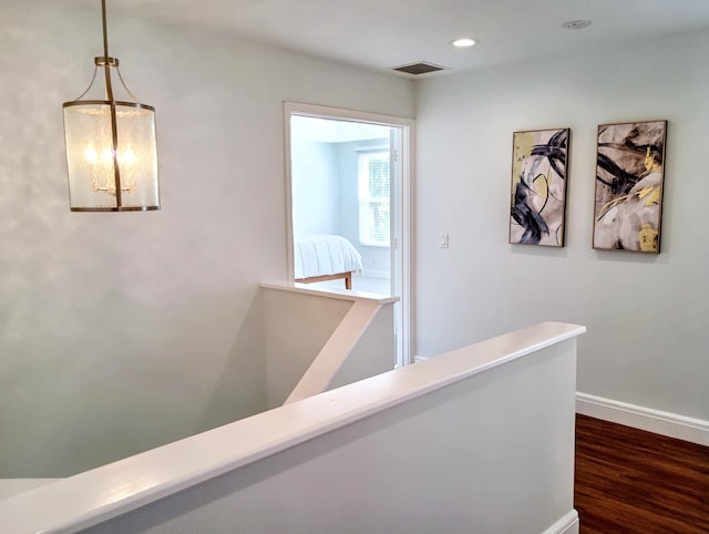 hall with dark wood-style flooring, visible vents, baseboards, an upstairs landing, and recessed lighting