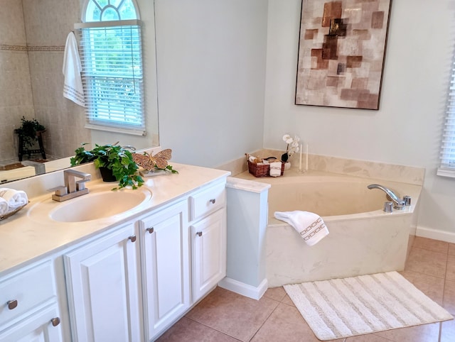 full bath with tile patterned floors, a garden tub, and vanity