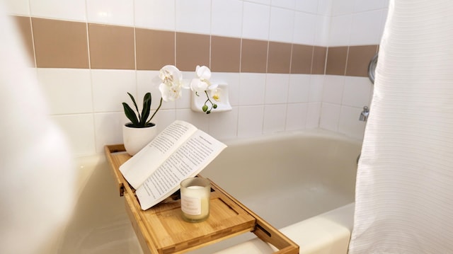 details featuring a tub to relax in and curtained shower