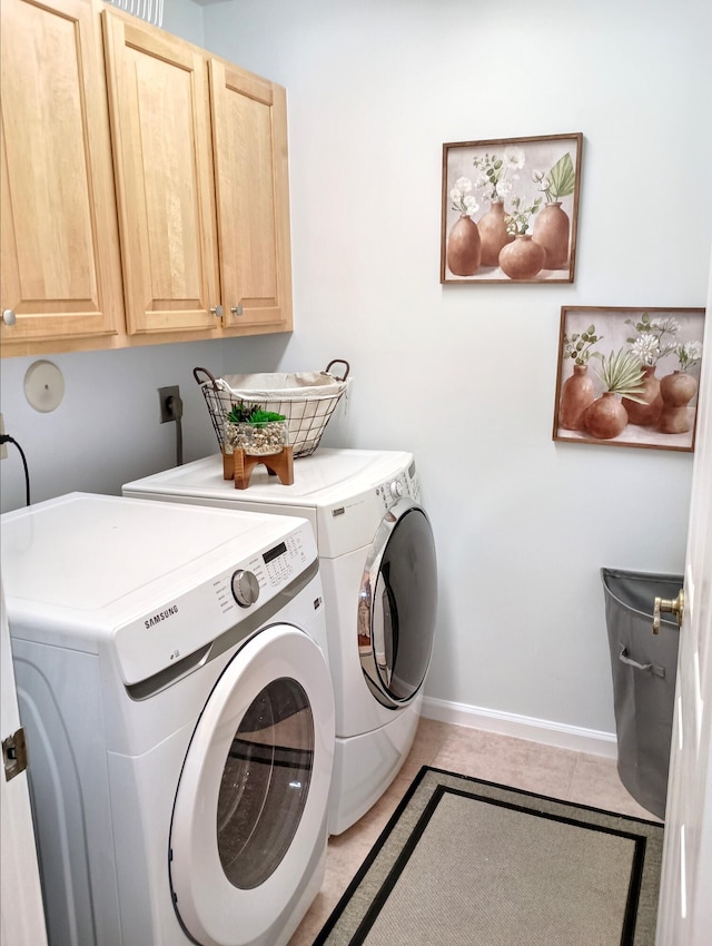 clothes washing area with light tile patterned floors, baseboards, cabinet space, and washer and dryer