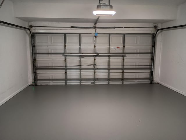 garage with baseboards and a garage door opener