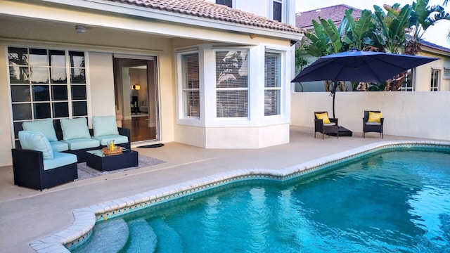view of swimming pool with a patio, an outdoor living space with a fire pit, and a fenced in pool