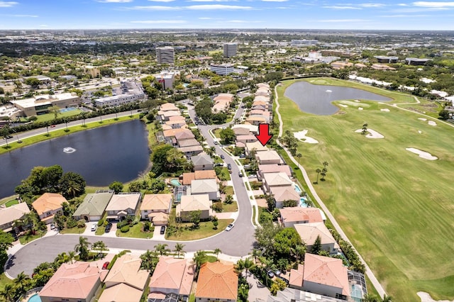 drone / aerial view featuring a water view, view of golf course, and a residential view