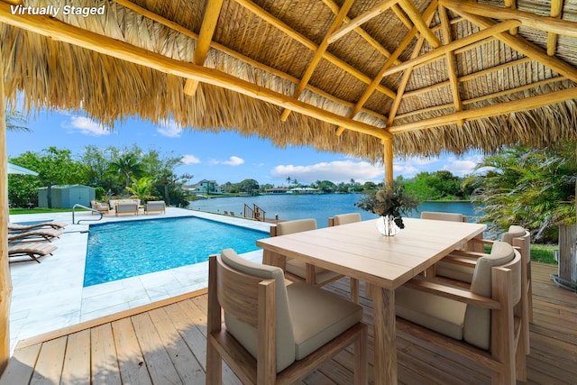 6803 Kingston Dr, Lake Worth, FL 33462 - outdoor pool featuring a storage shed, a gazebo, outdoor dining space, an outbuilding, and a deck with water view