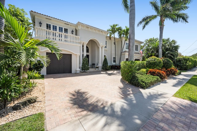712 NE 71st St, Boca Raton, FL 33487 - mediterranean / spanish home featuring stucco siding, an attached garage, decorative driveway, and a balcony