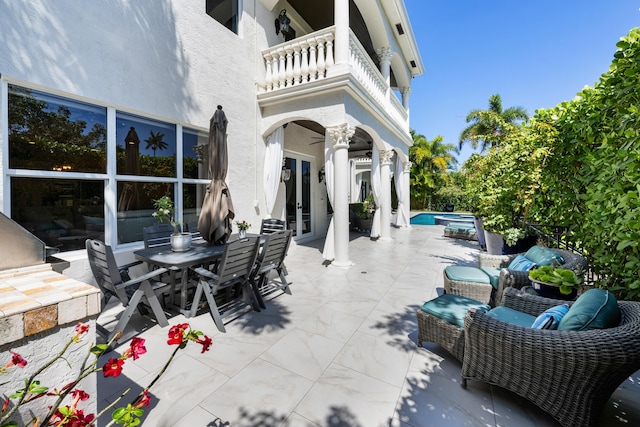 712 NE 71st St, Boca Raton, FL 33487 - view of patio with outdoor dining area, an outdoor pool, a balcony, and french doors