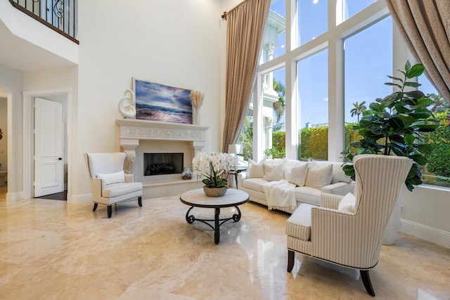 712 NE 71st St, Boca Raton, FL 33487 - living room featuring a fireplace with raised hearth, a high ceiling, and baseboards