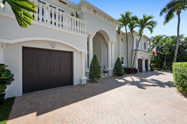 712 NE 71st St, Boca Raton, FL 33487 - mediterranean / spanish-style home featuring a garage, a balcony, decorative driveway, and stucco siding