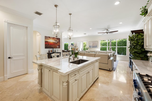 712 NE 71st St, Boca Raton, FL 33487 - kitchen with a sink, ceiling fan with notable chandelier, cream cabinets, arched walkways, and stainless steel range with gas stovetop