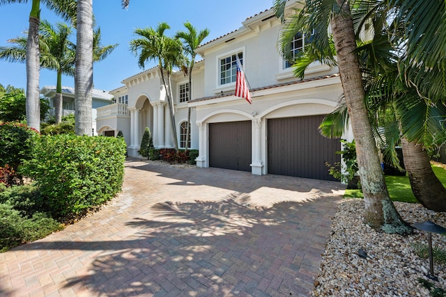 712 NE 71st St, Boca Raton, FL 33487 - mediterranean / spanish house featuring an attached garage, stucco siding, a balcony, and decorative driveway