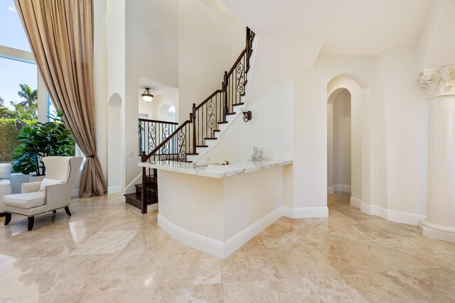 712 NE 71st St, Boca Raton, FL 33487 - entrance foyer featuring stairway, marble finish floor, arched walkways, a towering ceiling, and baseboards