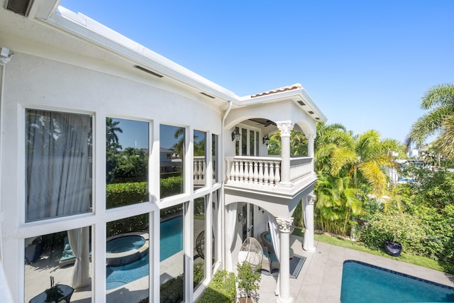 712 NE 71st St, Boca Raton, FL 33487 - exterior space with a patio, stucco siding, a balcony, a pool with connected hot tub, and a tiled roof