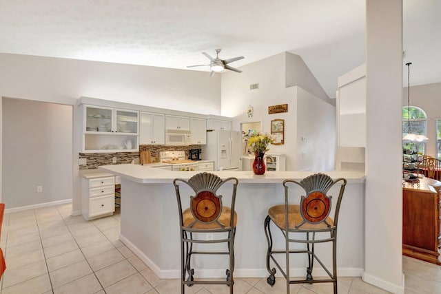 2857 SE Pace Dr, Port Saint Lucie, FL 34984 - kitchen featuring light countertops, a ceiling fan, white appliances, and a kitchen bar