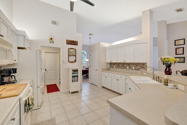 2857 SE Pace Dr, Port Saint Lucie, FL 34984 - kitchen featuring white appliances, visible vents, light countertops, a sink, and decorative backsplash