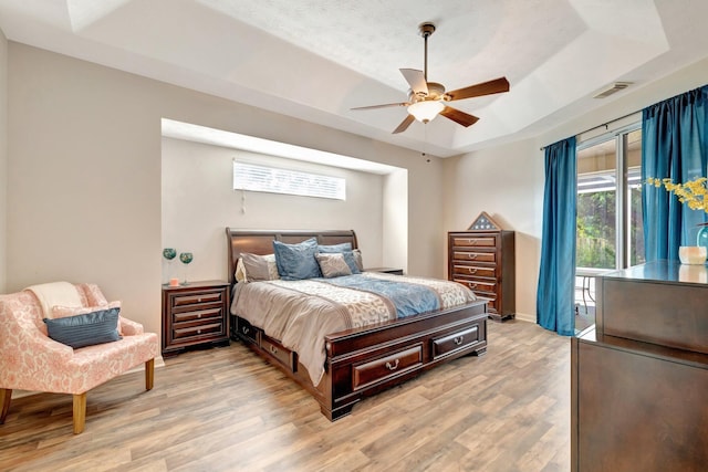 2857 SE Pace Dr, Port Saint Lucie, FL 34984 - bedroom featuring a tray ceiling, ceiling fan, light wood-style floors, and visible vents