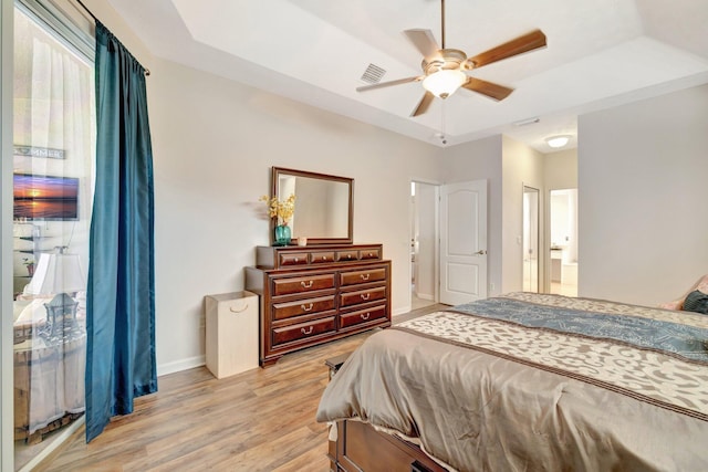 2857 SE Pace Dr, Port Saint Lucie, FL 34984 - bedroom featuring baseboards, a raised ceiling, a ceiling fan, light wood-style floors, and connected bathroom
