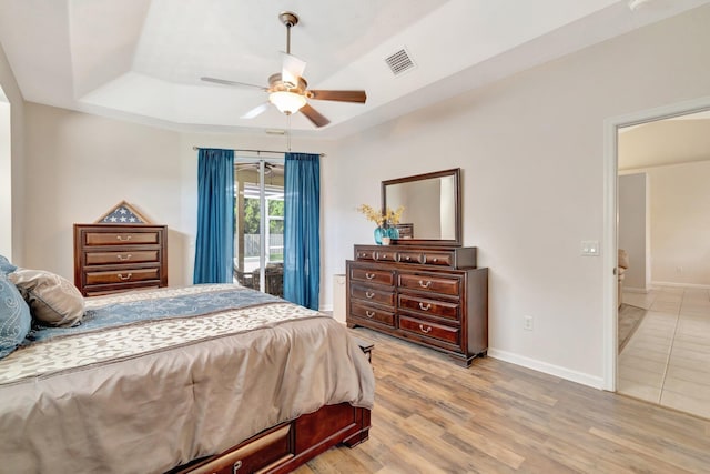 2857 SE Pace Dr, Port Saint Lucie, FL 34984 - bedroom featuring baseboards, visible vents, a tray ceiling, ceiling fan, and wood finished floors