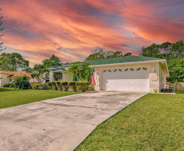 2857 SE Pace Dr, Port Saint Lucie, FL 34984 - view of front of home featuring a yard, an attached garage, driveway, and stucco siding