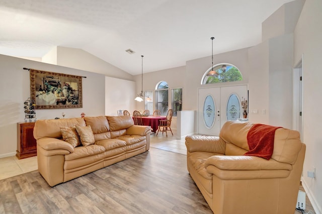 2857 SE Pace Dr, Port Saint Lucie, FL 34984 - living room with light wood finished floors, visible vents, baseboards, and vaulted ceiling