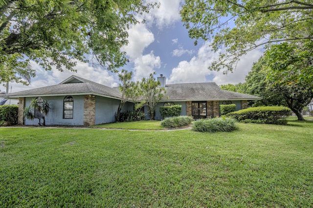 view of front of property with a chimney, stucco siding, and a front lawn
