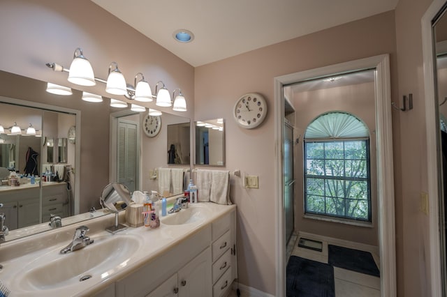 full bath featuring a sink, baseboards, and double vanity