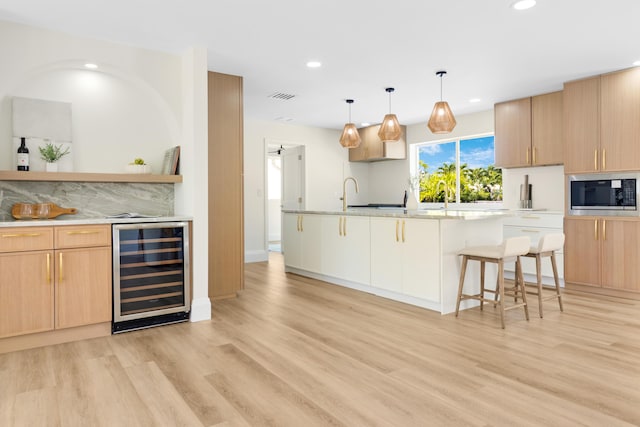 841 SE 5th Ter, Pompano Beach, FL 33060 - interior space with stainless steel microwave, light wood-type flooring, visible vents, recessed lighting, and beverage cooler