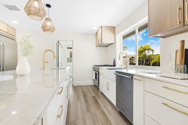 841 SE 5th Ter, Pompano Beach, FL 33060 - kitchen with light wood-style flooring, a sink, visible vents, premium appliances, and pendant lighting