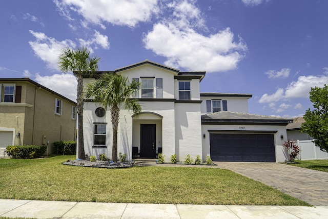 view of front of home with an attached garage, a front lawn, decorative driveway, and stucco siding