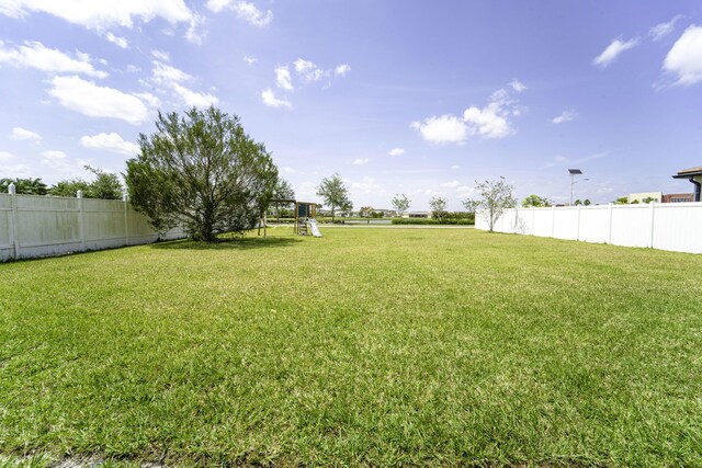 view of yard with fence and a playground