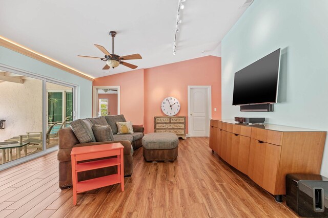 living area with vaulted ceiling, light wood-style flooring, rail lighting, and ceiling fan