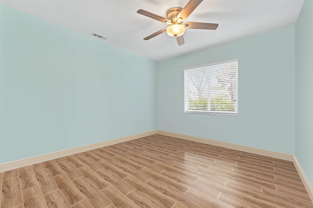 empty room featuring visible vents, baseboards, light wood-style floors, and ceiling fan