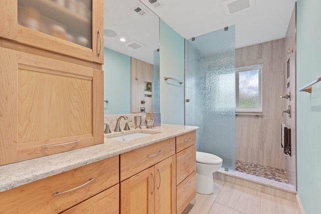 full bath with toilet, vanity, visible vents, and a stall shower