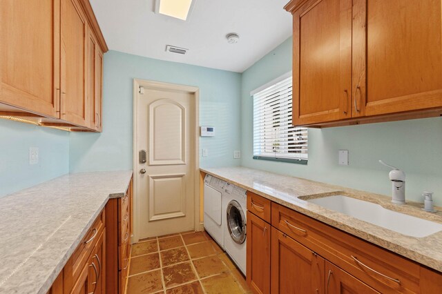washroom with washer and clothes dryer, visible vents, a sink, and cabinet space