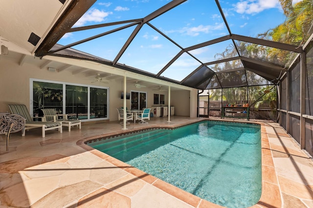 outdoor pool with ceiling fan, a lanai, and a patio