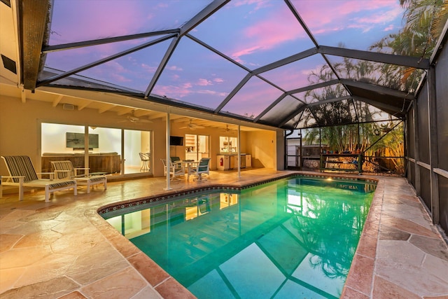 outdoor pool with ceiling fan, a lanai, and a patio
