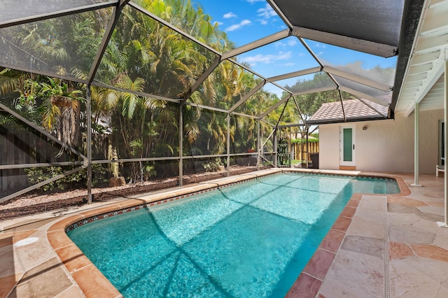 outdoor pool with a fenced backyard, a lanai, and a patio area