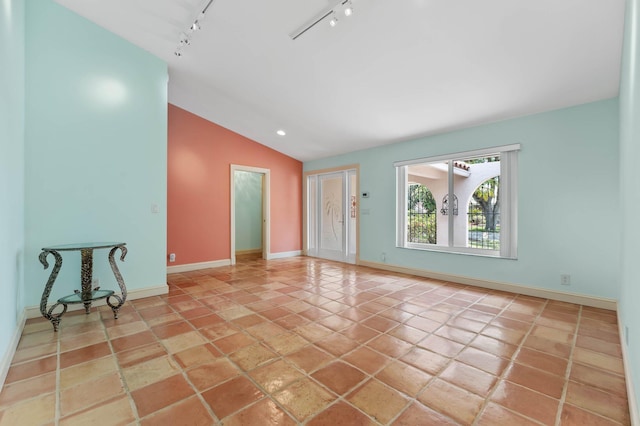 interior space featuring track lighting, baseboards, and vaulted ceiling