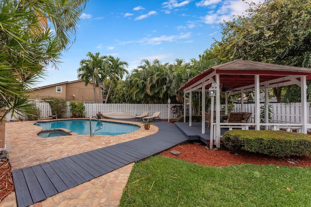 view of pool with a fenced backyard, a gazebo, a deck, and a pool with connected hot tub