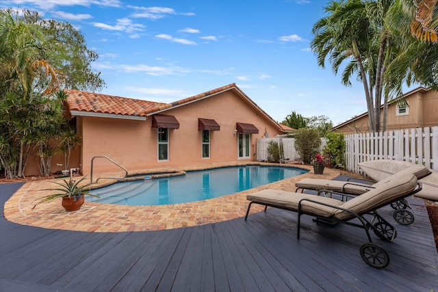 view of swimming pool featuring a fenced backyard, a wooden deck, and a fenced in pool