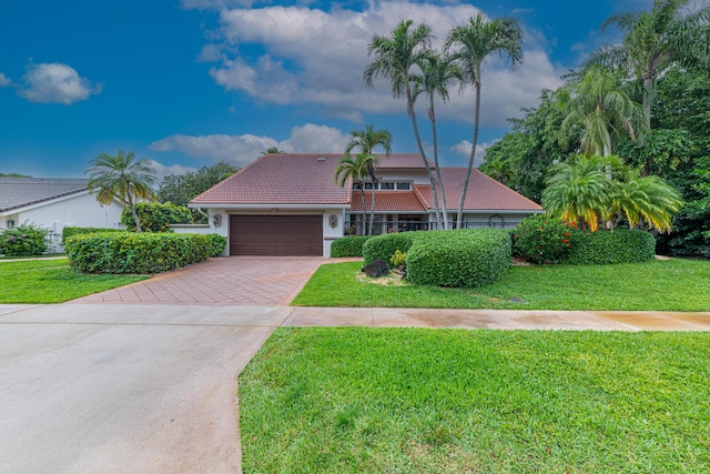 10503 Boca Woods Ln, Boca Raton, FL 33428 - view of front facade featuring a garage, a tile roof, stucco siding, a front lawn, and driveway