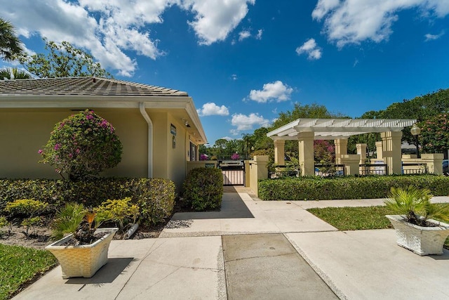 5166 SE Inkwood Way, Hobe Sound, FL 33455 - view of side of home with a pergola, a gate, and stucco siding