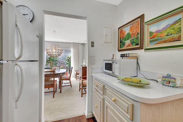 10129 43rd Dr S Unit 311, Boynton Beach, FL 33436 - kitchen with white appliances, electric panel, light countertops, a chandelier, and dark wood finished floors